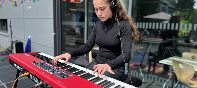 A pupil plays the piano on stage at Europe Day at Gronau Comprehensive School