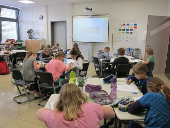 Pupils listen to a teacher