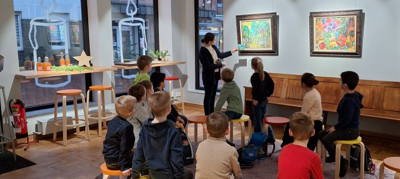 Visita a la galería Una mujer explica a los niños cómo pintar con acuarela