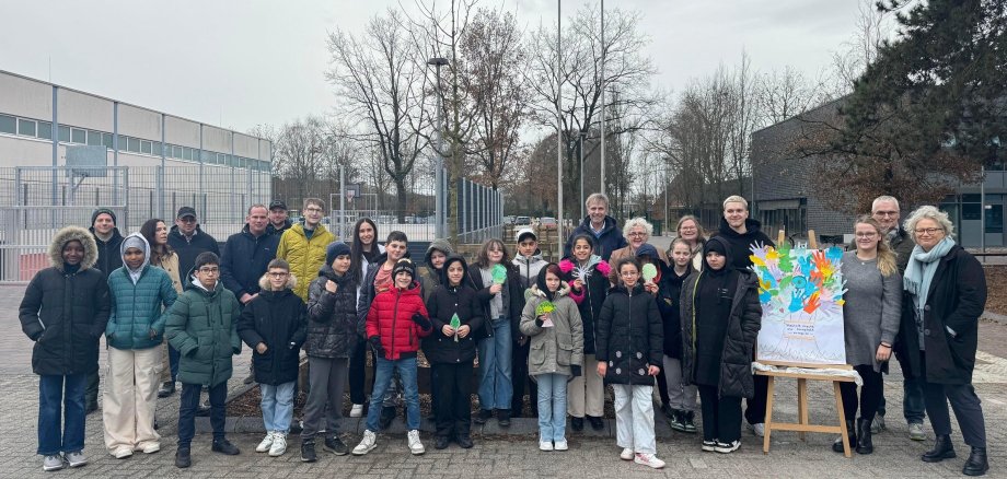 Pormestari Rainer Doetkotte, kaupunkisuunnittelupäällikkö Ralf Groß-Holtick, ensimmäinen apulaispormestari Christiane Schrader, rehtori Steuer, peruskoulun oppilaat ja muut hankkeeseen osallistuneet uuden leikkikentän edessä.