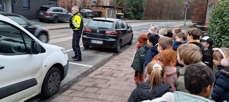 Verkeerspolitie Politieagent legt kinderen uit hoe ze correct kunnen oversteken