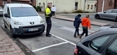 Verkeerspolitie Twee kinderen steken de weg over met een politieagent