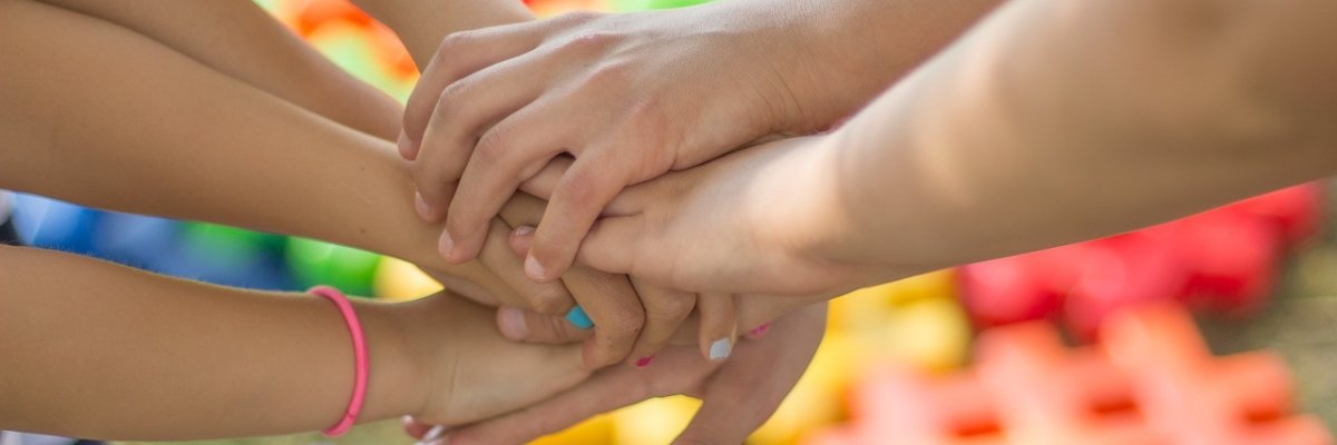 As mãos são colocadas umas sobre as outras num círculo.