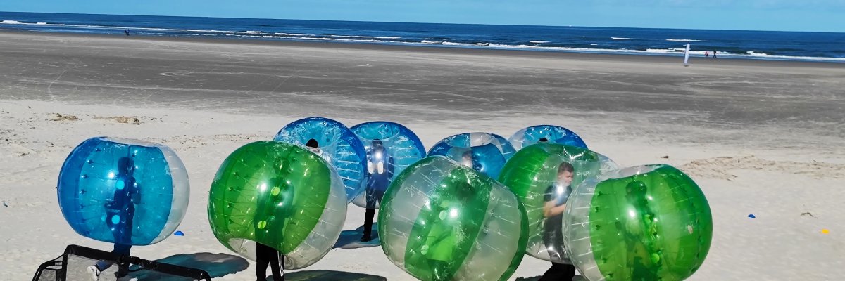 Copiii joacă bubbleball pe plajă