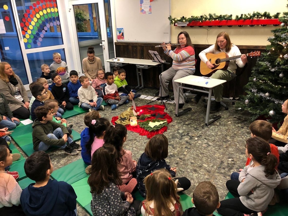 Cântece de Advent Două femei cântă la instrumente, iar copiii cântă împreună