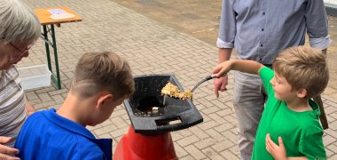 Мальчик кладет кусочки яблок в измельчитель