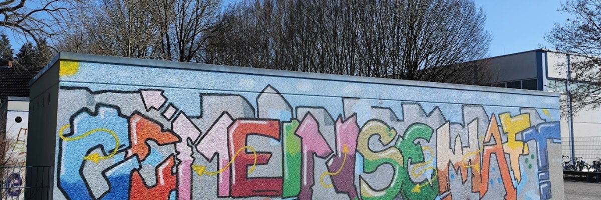 Graffiti av skolans namn på garageväggen